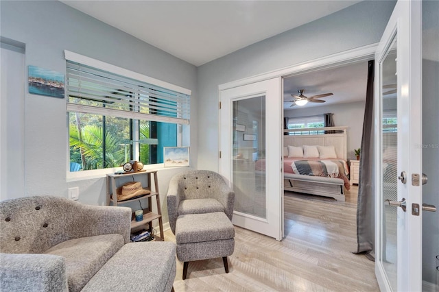 sitting room featuring light wood finished floors and french doors