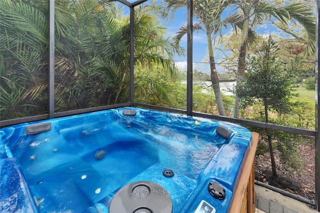 view of swimming pool with glass enclosure and a jacuzzi