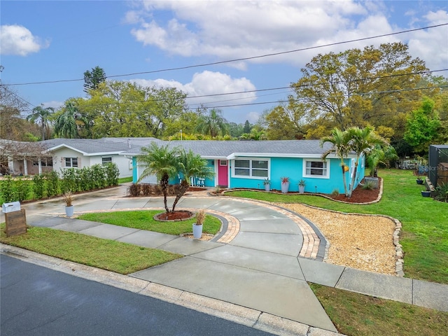 single story home with stucco siding, concrete driveway, and a front lawn