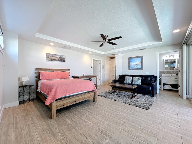 bedroom featuring a textured ceiling, a tray ceiling, visible vents, and recessed lighting