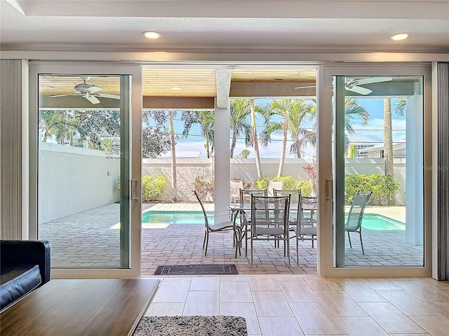 doorway featuring tile patterned flooring, a ceiling fan, a wealth of natural light, and recessed lighting