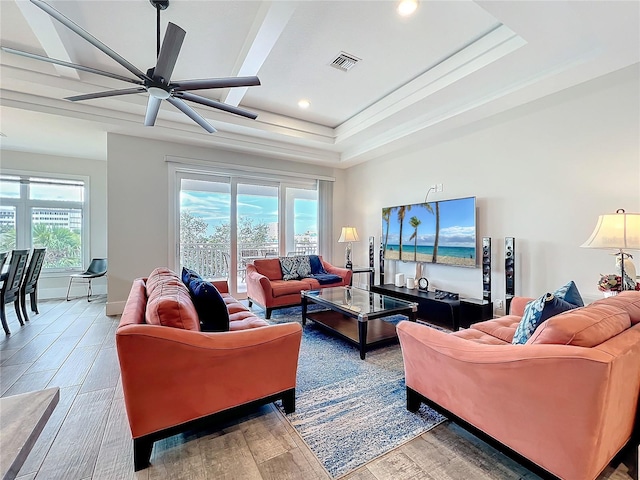 living room with ceiling fan, visible vents, plenty of natural light, and wood finished floors