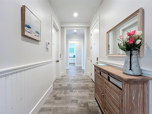 hallway with a wainscoted wall and wood finished floors