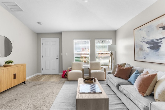 living area featuring baseboards, visible vents, and light wood-style flooring