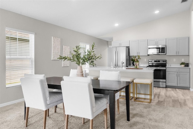 dining area featuring recessed lighting, visible vents, light carpet, vaulted ceiling, and baseboards