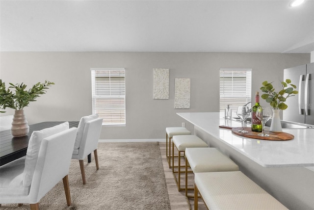 dining area featuring light colored carpet and baseboards