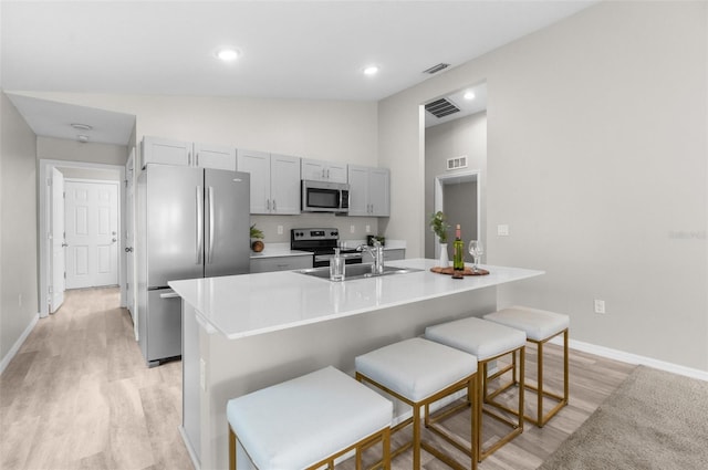 kitchen featuring visible vents, appliances with stainless steel finishes, a sink, and gray cabinetry