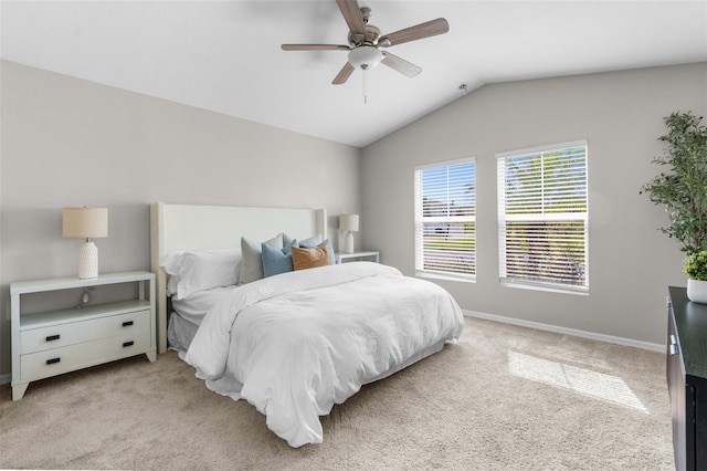 bedroom featuring lofted ceiling, baseboards, a ceiling fan, and light colored carpet