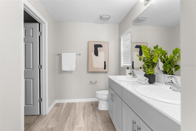 full bathroom with wood finished floors, a sink, and visible vents