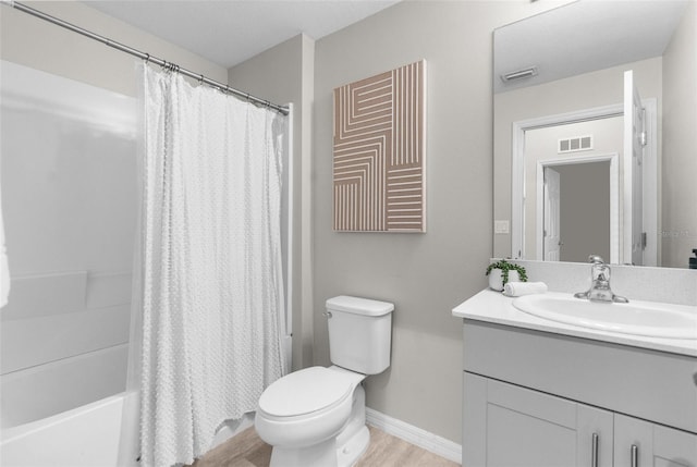 bathroom with baseboards, visible vents, toilet, wood finished floors, and vanity