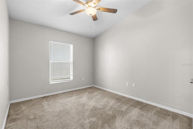 carpeted spare room with baseboards and a ceiling fan