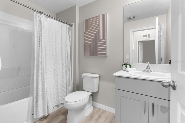 full bathroom featuring toilet, wood finished floors, visible vents, vanity, and baseboards