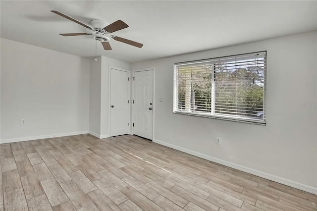 spare room featuring ceiling fan, baseboards, and wood finished floors