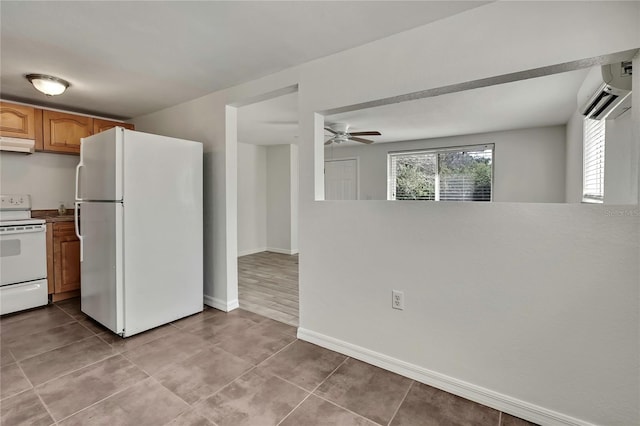 kitchen with white appliances, baseboards, tile patterned floors, under cabinet range hood, and a wall mounted AC