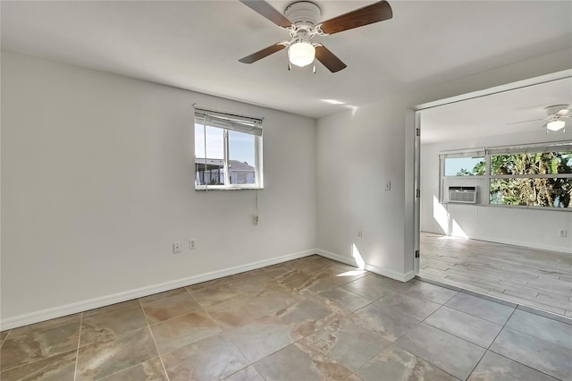 tiled spare room featuring cooling unit, baseboards, and a ceiling fan