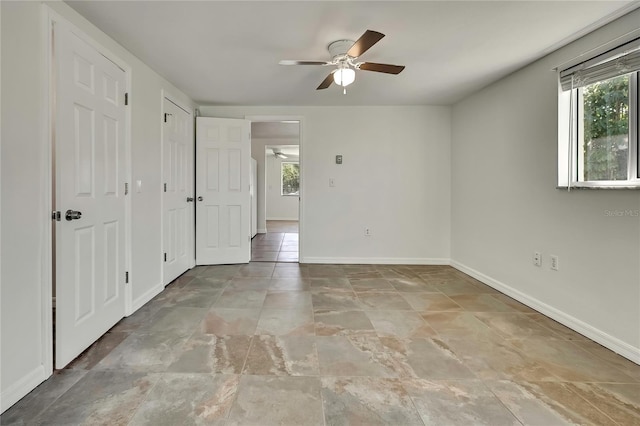 spare room with baseboards and a ceiling fan