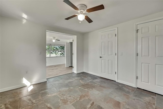 unfurnished bedroom with a ceiling fan and baseboards