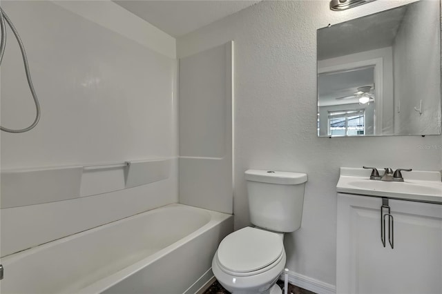 full bath featuring shower / bath combination, baseboards, a textured wall, toilet, and vanity