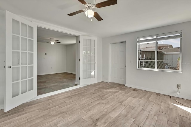 unfurnished room featuring a ceiling fan, baseboards, wood finished floors, and french doors