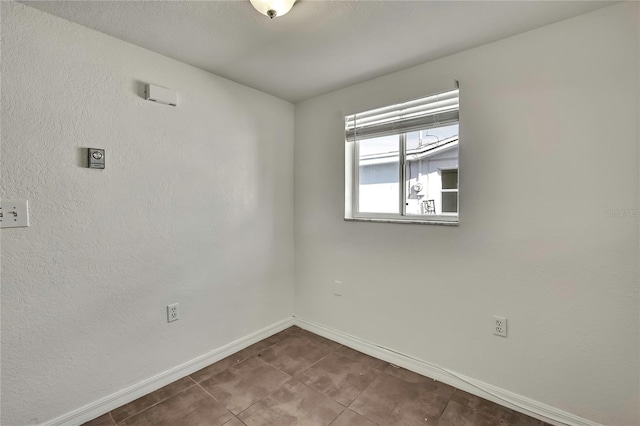 spare room with baseboards