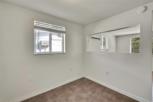 empty room featuring baseboards and a wealth of natural light