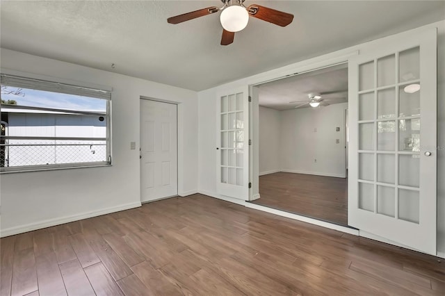 empty room featuring french doors, baseboards, and wood finished floors