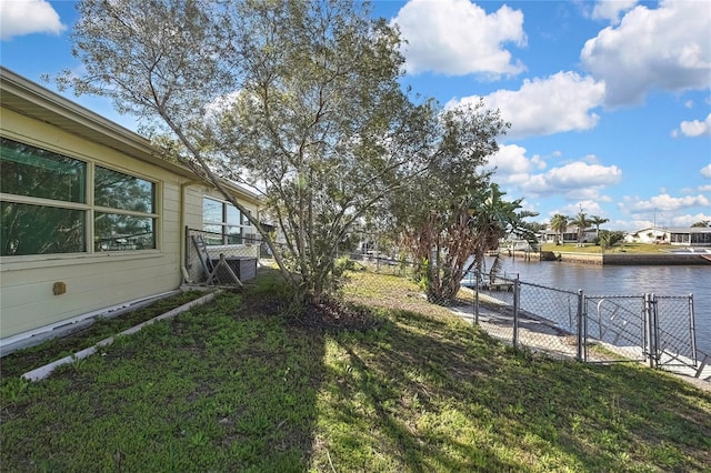 view of yard with a water view, a gate, and fence