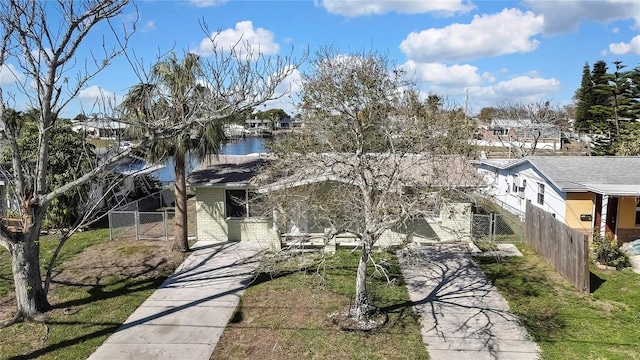 view of front of home with a water view, fence, and brick siding