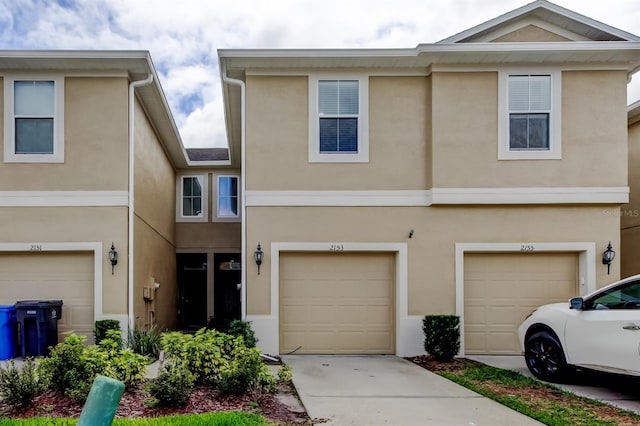 view of property featuring an attached garage and stucco siding