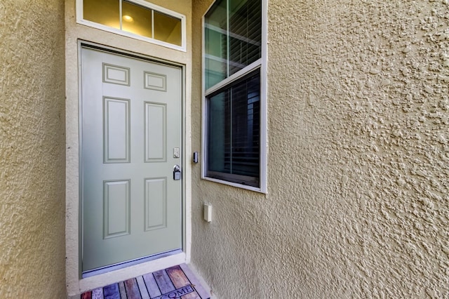 view of exterior entry featuring stucco siding