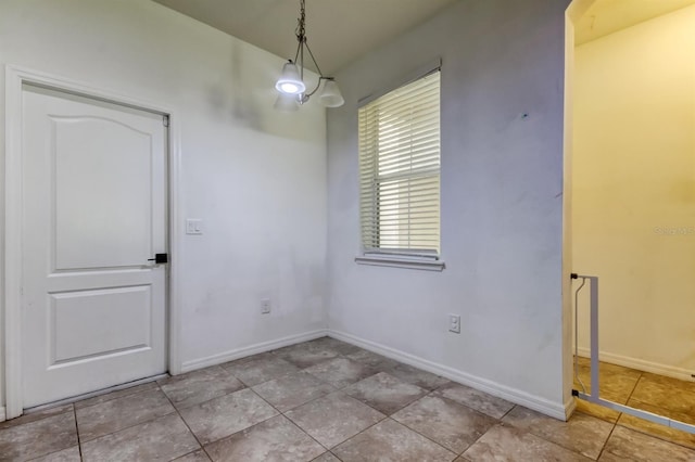 unfurnished dining area featuring tile patterned flooring and baseboards