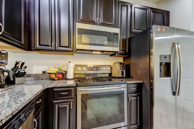 kitchen with stainless steel appliances, dark brown cabinetry, and light stone countertops