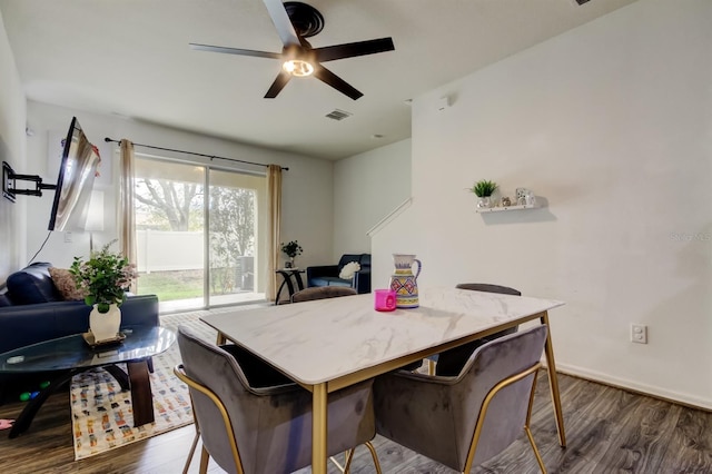 dining area with baseboards, visible vents, a ceiling fan, and dark wood-type flooring