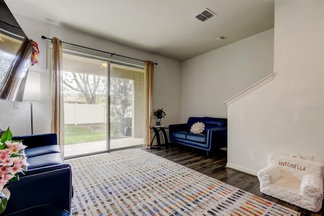 sitting room with wood finished floors, visible vents, and baseboards