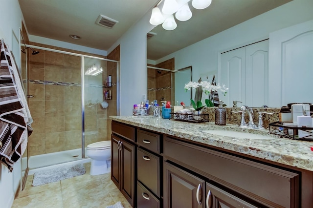 bathroom with a sink, a shower stall, toilet, and double vanity