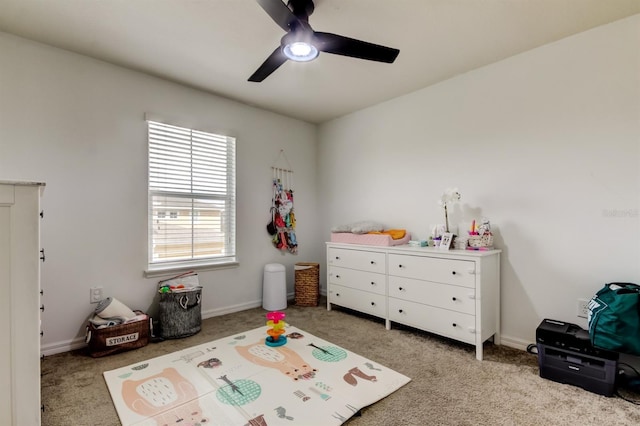 bedroom with carpet floors, baseboards, a crib, and a ceiling fan