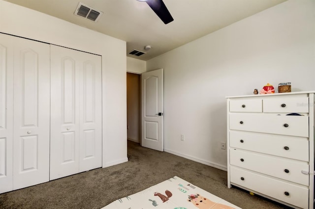 unfurnished bedroom with dark colored carpet, a closet, visible vents, and baseboards