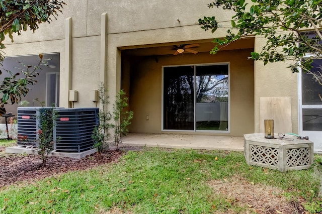 doorway to property with ceiling fan, central AC unit, a patio area, and stucco siding