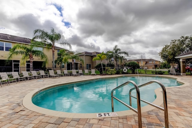 community pool featuring fence and a patio