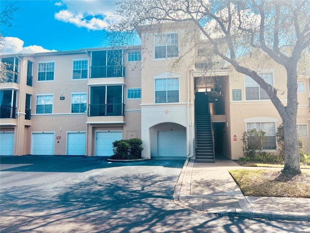 view of property featuring stucco siding, an attached garage, and driveway