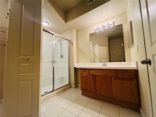 bathroom featuring a stall shower, visible vents, baseboards, tile patterned flooring, and vanity