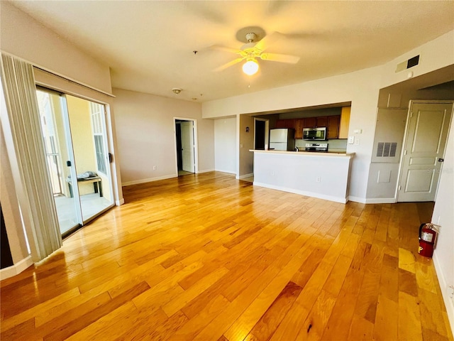 unfurnished living room with visible vents, light wood-style flooring, and baseboards