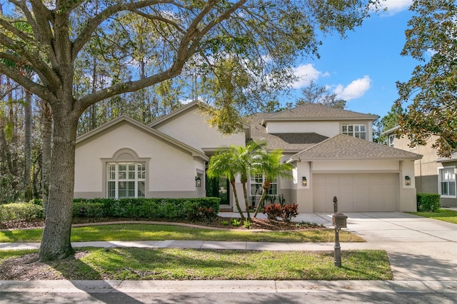 view of front of home with concrete driveway, roof with shingles, an attached garage, and stucco siding