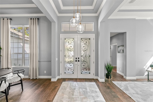 foyer with baseboards, a raised ceiling, wood-type flooring, crown molding, and french doors