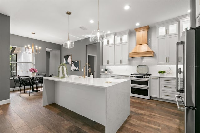 kitchen with range with two ovens, light countertops, custom range hood, decorative backsplash, and freestanding refrigerator