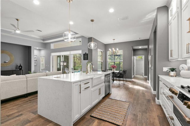 kitchen featuring dark wood-style flooring, visible vents, appliances with stainless steel finishes, white cabinets, and a sink