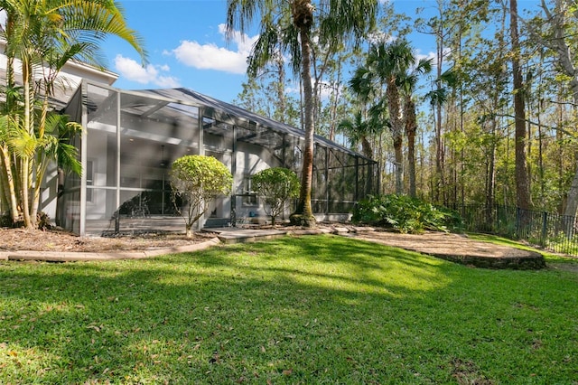 view of yard featuring glass enclosure and fence