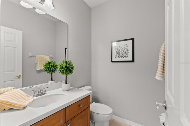 bathroom featuring toilet, tile patterned flooring, vanity, and baseboards