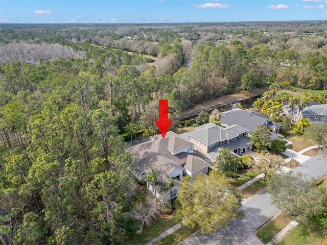 drone / aerial view with a wooded view and a residential view