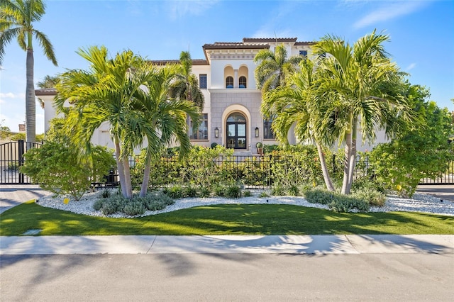 mediterranean / spanish house featuring a front yard and fence